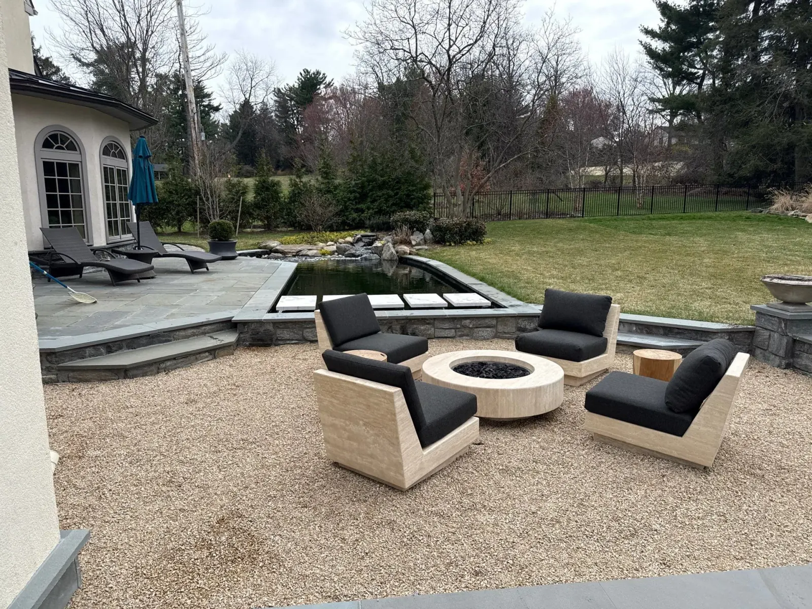 Recently completed custom stone patio with built-in seating and fire feature