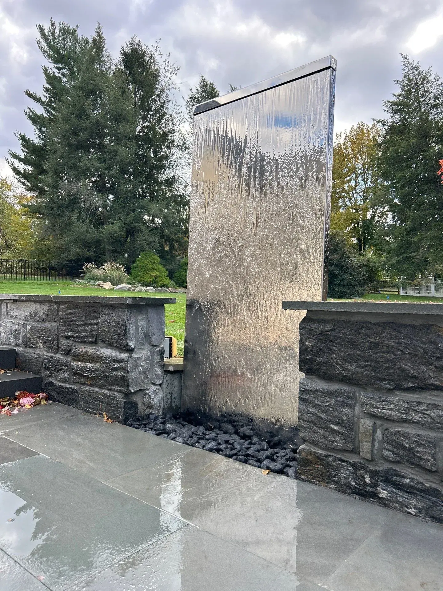 Recently completed contemporary stone fountain wall and basin