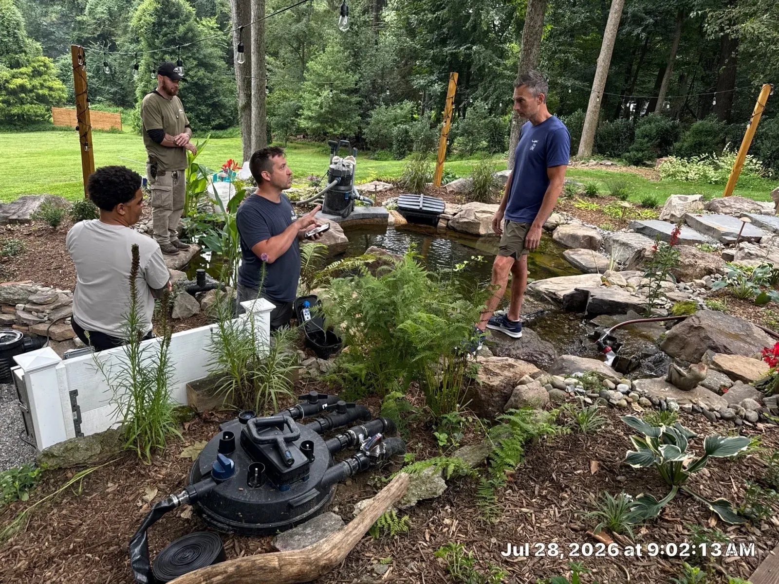 Rock Water Ponds team caring for an established backyard pond