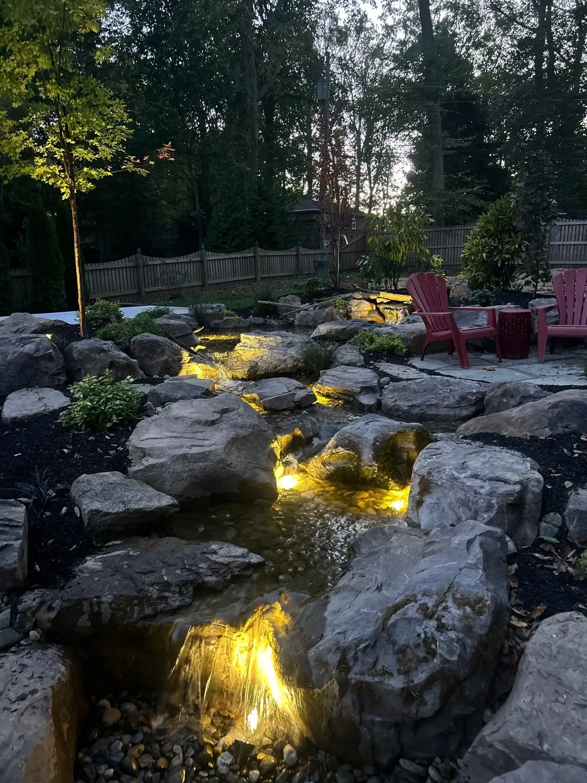 Custom waterfall design with natural boulders and cascading water